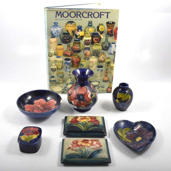 Seven pieces of Moorcroft Pottery and a book.