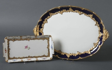 Two trays Meissen, 1953, porcelain, glazed, the oval tray with cobalt blue flag, rich matt and bright gold decoration in relief and rocaille handles, the second tray rectangular, on the flag scattered flowers, in the mirror single scattered flowers in...