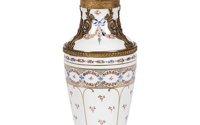 Vase en porcelaine émaillée de type Sèvres avec garniture en laiton doré. Décor floral peint...