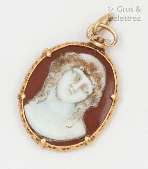 Yellow gold pendant with openwork volutes and foliage, decorated with a cameo representing a young man in bust glued on an agate plate. Length : 3,5cm. Weight : 6,1g.