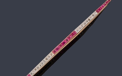 Broche - barrita con banda de rubíes calibrados y diamantes intercalados, en montura de oro amarillo de 18K.