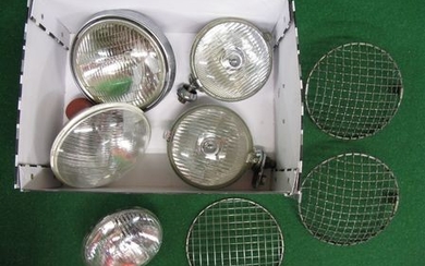 Box of chromed headlamps and Lucas spot lamps together with stone guards