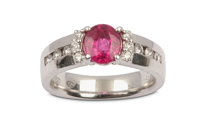 A ruby and diamond ring The oval-cut ruby,...