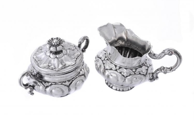 A silver cream jug and sugar basin and cover