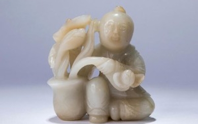 A WHITE JADE CARVING OF A BOY WITH LOTUS