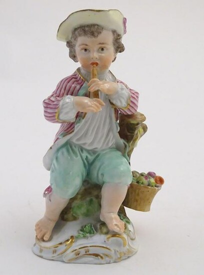 A Continental porcelain figure of a boy playing a