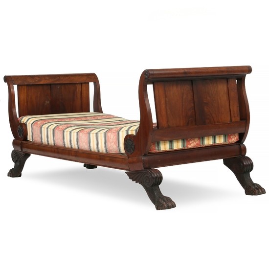 A Danish West Indian late Empire mahogany bed with lion paws. Ca. 1830. Inner lenght 188 cm. Inner depth 82 cm.(mattress and tube shaped end pillows enclosed)