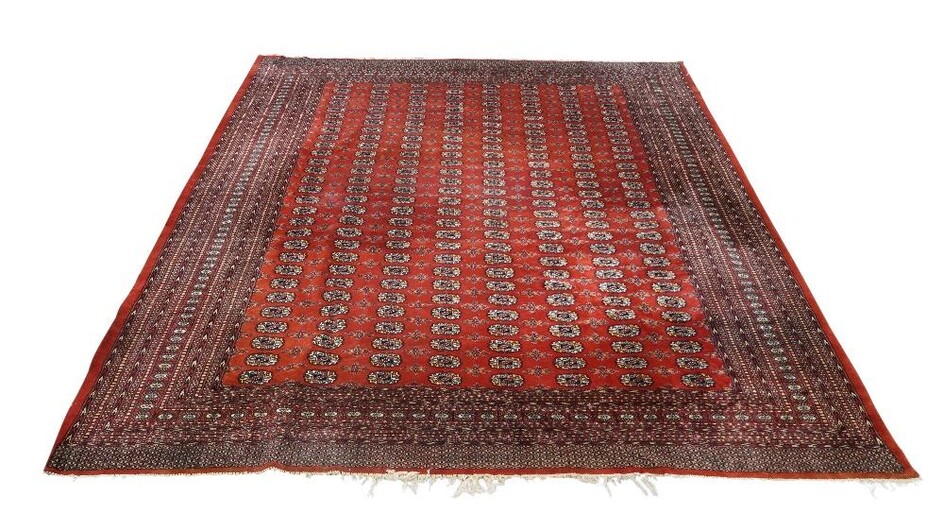 A Pakistani Bokhara red ground carpet, mid 20th century, with central repeating gull motifs, on a red ground, contained repeating borders, 360cm x 302cm Provenance: The Geoffrey and Fay Elliot collection.