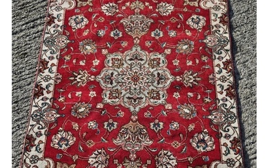 A Persian Tabriz Red ground Rug with a rich Red ground and a...
