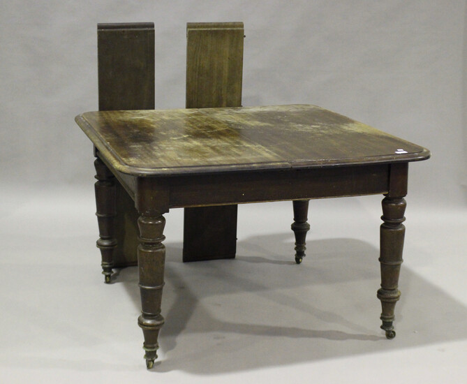 A Victorian mahogany extending dining table with two extra leaves, on turned legs and castors, heigh