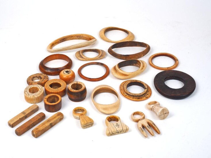A group of large mixed African ivory bangles, 19th century, of varying patinas and sizes, some with additional decoration and various traditional repairs, some with additional metal terminals, bound with leather, approx. 11cm diameter (4)