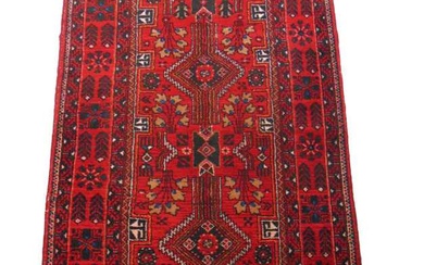A handwoven Persian rug, the multi line border surrounding a...