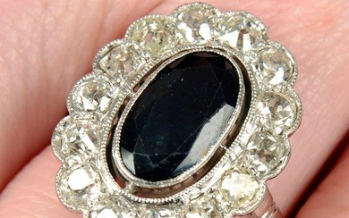 A mid 20th century platinum sapphire and old-cut diamond cluster ring.Sapphire calculated weight
