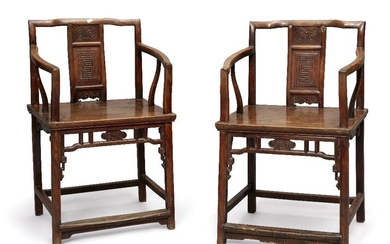 A pair of Chinese walnut armchairs, early 19th century, the central splat carved with a ruyi above a shou character, the solid seat above pierced frieze decorated with a further ruyi, 91cm high. (2） 十九世紀早期 胡桃木雕椅一對