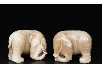 A pair of Chinese white and russet jade sculptures of elepha...