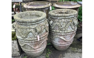 A pair of large reconstituted stone gardens urns with rope m...