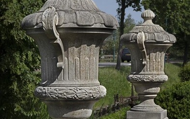 A pair of monumental carved limestone urns-and-covers