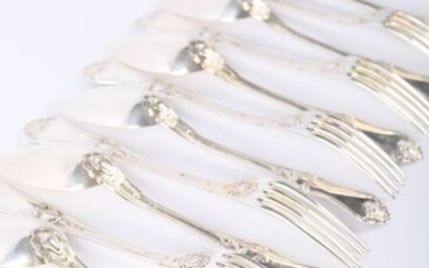 A suite of twelve silver cutlery with a silver plated centrepiece, the moving handle decorated with nets, waves and windings.