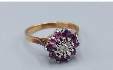 An 18ct gold Diamond and Ruby set cluster ring with a centra...
