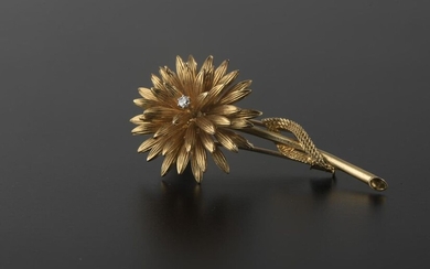 Engraved 18k yellow gold lapel clip featuring a flower, the centre adorned with a round brilliant cut diamond.