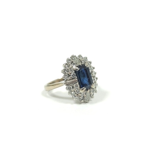 Diamond and sapphire oval cluster ring with four tapering ba...