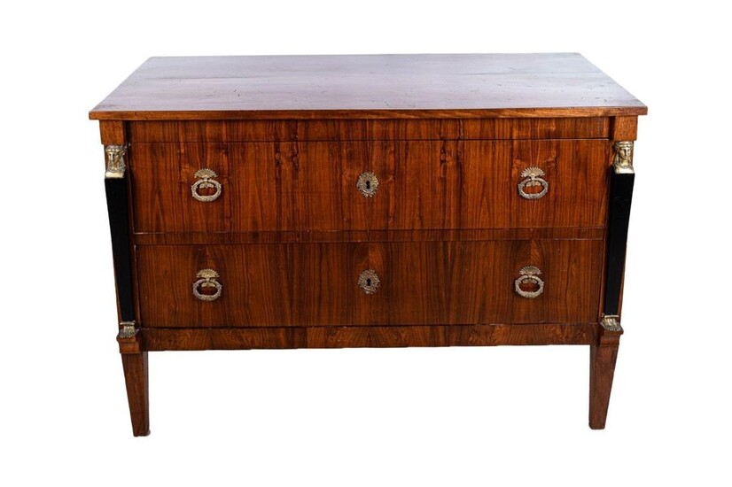 Empire style dresserLigurian manufacture, mid 19th centuryin walnut wood, with two drawers, rectangular top, truncated pyra midal legs, decorated with herm-shaped pilasters in ebonized wood and bronze, bronze key and handles87 x 126.5 x 54.5 cm