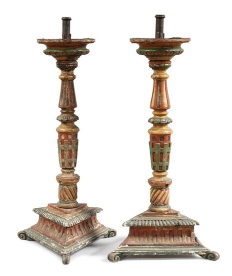 Pair of TRIPODE CANDLE STICKS made of polychrome molded and carved wood. The upper part is decorated with a row of ovals, the baluster shaft ending in an openwork basket surmounting a twisted pattern. The triangular base is supported by scrolled legs...