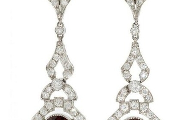 Pair of long earrings with movement, in 18 kts. white gold with diamonds and garnets with ca. 1.13