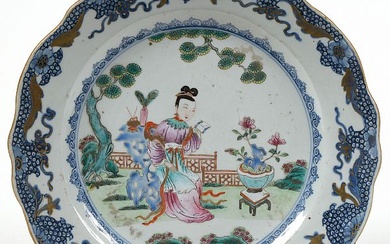 Plat chantourné en porcelaine polychrome de Chine décoré d’une "Guanyin dans un paysage". Epoque: XVIIIème. Diam.:+/-28,3cm.