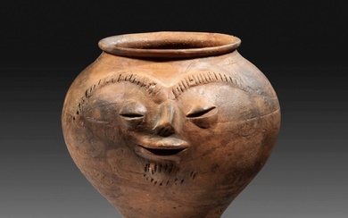 Roman facial urn made of reddish brown terracotta.