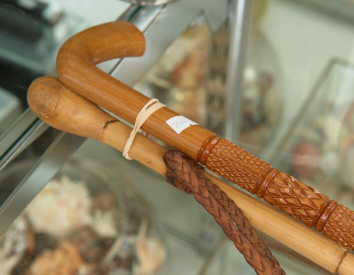 TWO 1940S WALKING STICKS, ONE FULLY CARVED, THE OTHER CANE WITH LEATHER STRAP