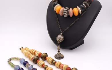 Trois colliers dont un en perles de verre, et une chaîne en métal à pendentif