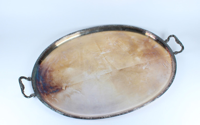 Vassoio ovale in metallo argentato biansato con bordo scanalato decorato da rametti di ulivo, anse a volute contrapposte (cm 74x50)…