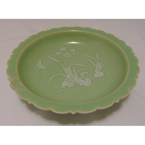A Chinese celadon glazed bowl with scalloped border decorate...