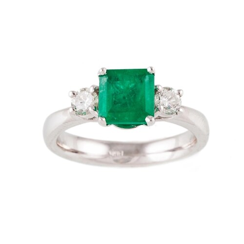 A DIAMOND AND EMERALD THREE STONE RING, the trap cut emerald...