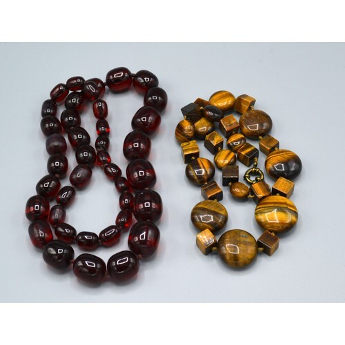 A Graduated Amber Bead Necklace together with a tiger's eye ...