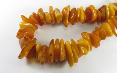 A LONG BUTTER AMBER BEAD NECKLACE