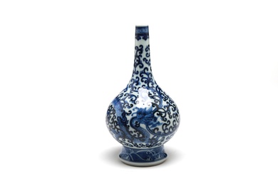 A blue and white porcelain bottle vase painted with dragons amidst floral vine scrolls among foaming waves