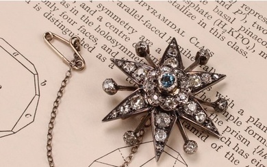 A diamond radiating starburst brooch, set with old cut stone...