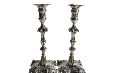 A good pair of George III silver candlesticks, upon shaped s...