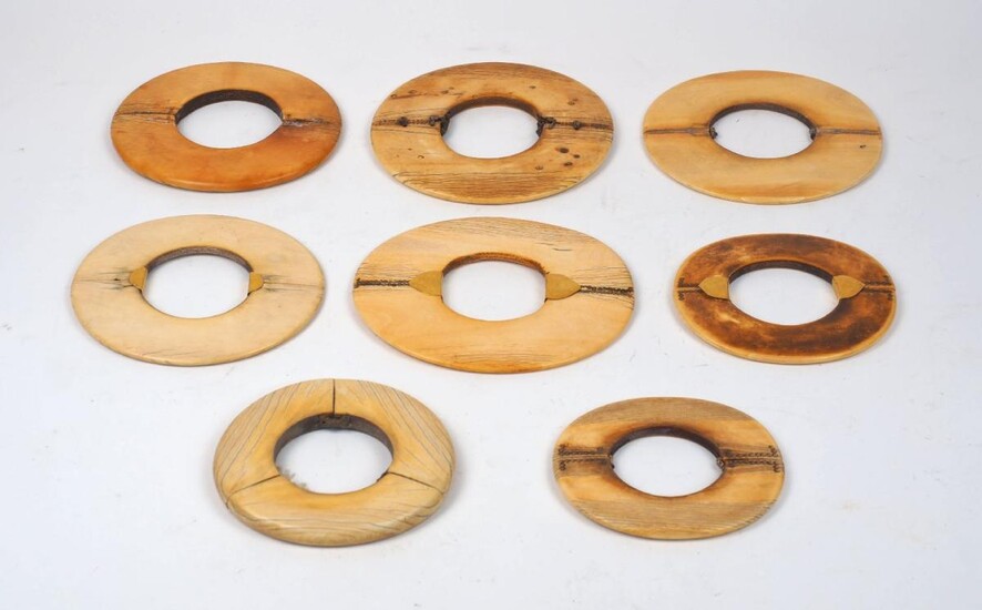 A group of large mixed African ivory bangles, 19th century, of varying patinas and sizes, some with additional decoration, various traditional repair and additional metal terminals, bound with leather, approx. 11cm diameter (5)