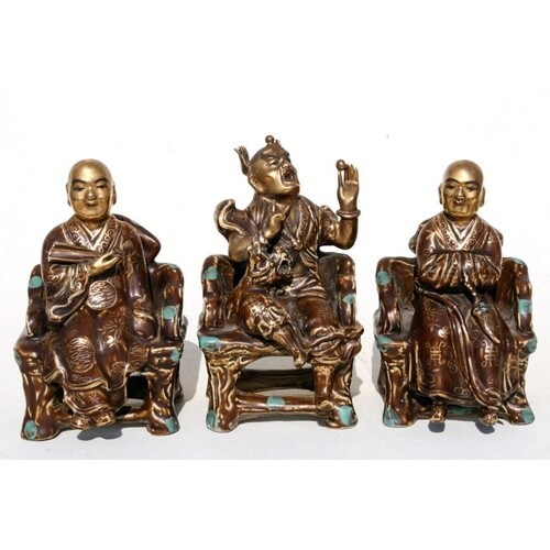 A group of three Chinese glazed pottery robed figures seated...