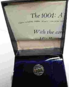 A lapel pin for The 1001: A Nature Trust, depicting a globe in gilt relief with blue enamel and 1001 in gilt relief across the centre, cased and with a printed card inscribed The 1001: A Nature Trust...With the compliments of His Royal Highness The...