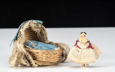 A miniature Grodnerthal dolls’ house doll in cradle