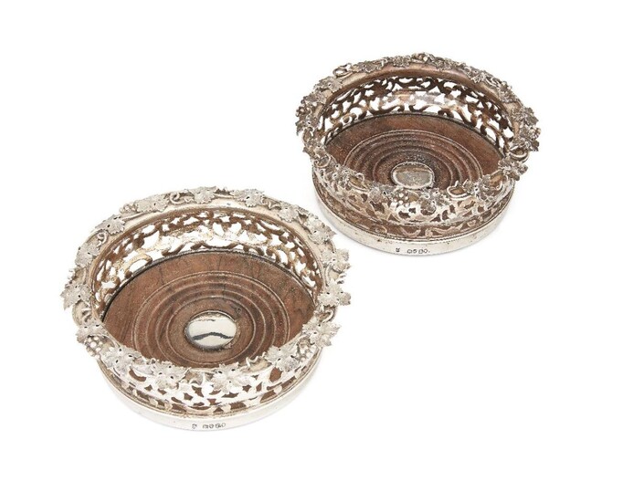 A pair of early Victorian silver wine coasters, London, 1838, Joseph Angell I & John Angell I, the pierced sides to applied fruiting vine rims and turned wooden bases, 16.5cm dia. (2)