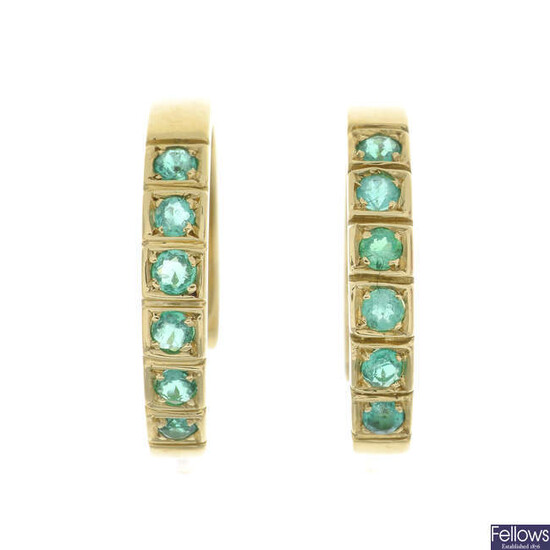 A pair of emerald hoop earrings.