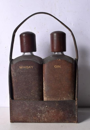 A pair of vintage leather encased glass decanters with purpose made leather carrier. 25 x 20cm (3).