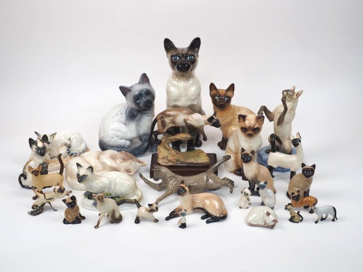 A quantity of pottery Siamese cats, to include; a large seated Beswick cat, stamped Beswick England 2139 to base, 36cm high, two Royal Doulton cats, both with factory stamp to base, HN numbers 2655 and 2602, a Royal Copenhagen cat with gold factory...