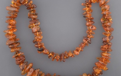 An Amber Necklace, ninety-five irregular shaped and sized orangey-brown amber...