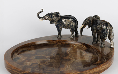 An Art Deco-period vide-poche decorated with two elephants. Brown onyx and silver painted metal. We